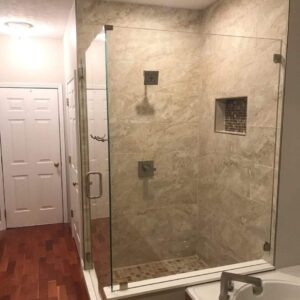 Modern bathroom with a large, glass-enclosed walk-in shower featuring beige tiles and mosaic accents.